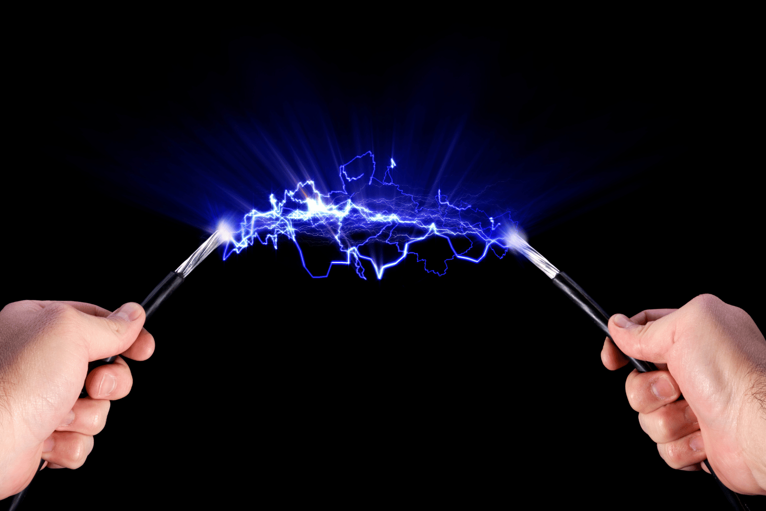 Two hands holding electrical wires with electricity flowing between them.