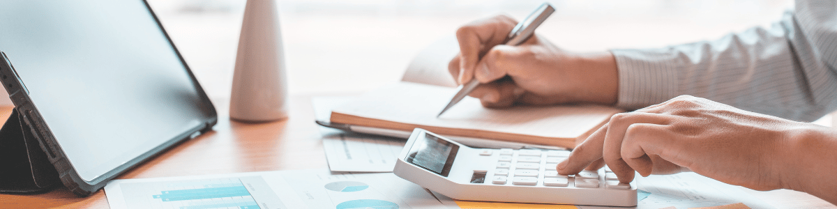 Small business owner on the computer looking at Meta's website using a calculator