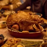 Cozy autumn Thanksgiving table with pumpkins, candles, and festive foods in warm seasonal colours.